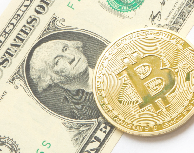 bitcoin next to dollar bill