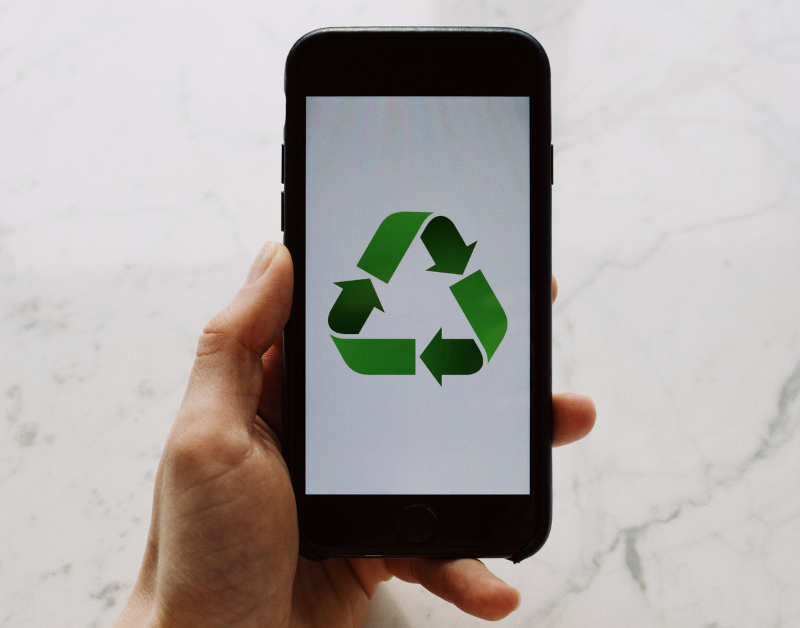 electronics recycling and e-waste disposal symbolized by phone with recycle logo on screen
